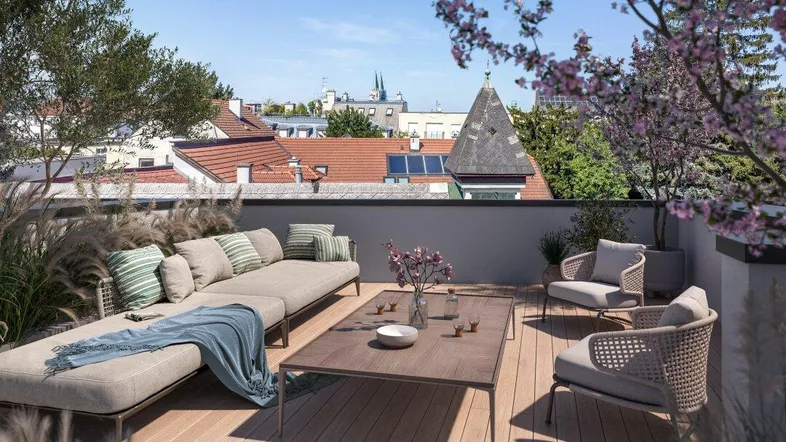 Moderne Dachterrasse mit bequemen Loungemöbeln und Blick über die Dächer der Stadt.