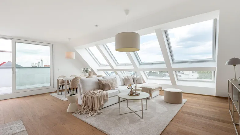 Helles und modernes Wohn-Esszimmer mit großen Dachfenstern, Holzboden und Zugang zur Terrasse.