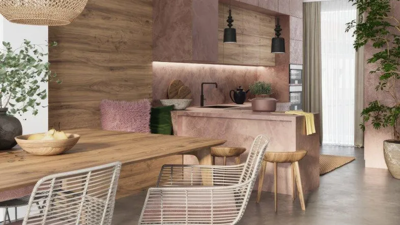 Moderne offene Küche mit rosafarbenen Schränken, Holztisch und Betonboden, offen gestaltet.