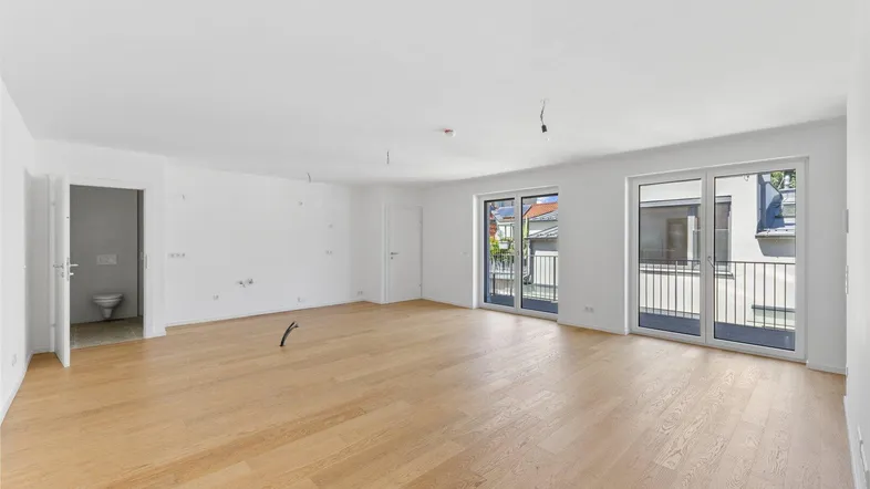 Helles, geräumiges Wohnzimmer mit Parkettboden und Zugang zu einem französischen Balkon.