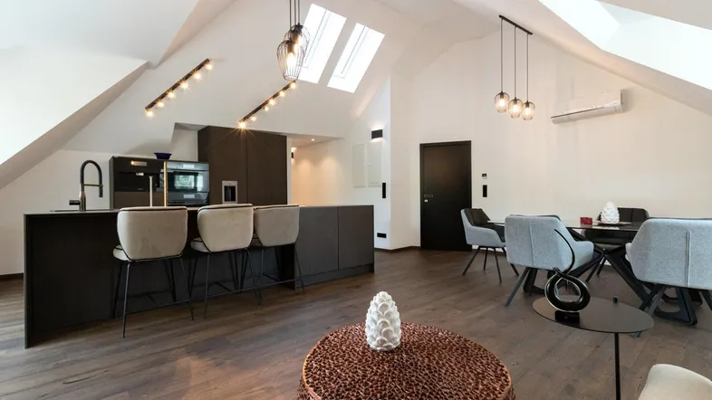 Moderne offene Küche mit Essbereich, Dachschrägen, Holzboden und Oberlichtern.