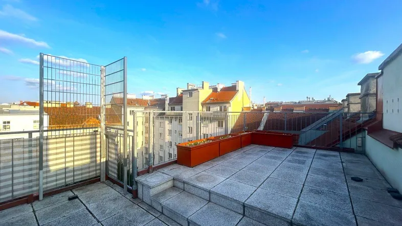 Geräumige Dachterrasse mit Fliesenboden, Stadtblick und Metallgeländer, ideal zum Entspannen.