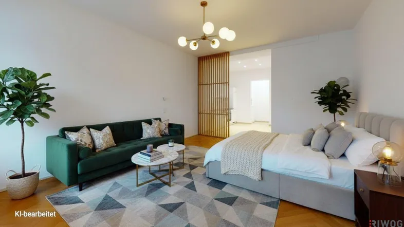 Modernes Wohnzimmer mit grünem Sofa, Parkettboden und offenem Übergang zum Schlafbereich.