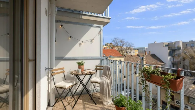 Gemütlicher Balkon mit Sitzgelegenheiten und Lichterkette, ideal für entspannte Stunden im Freien.