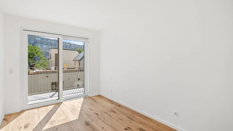Heller Raum mit Holzboden und Zugang zu einem Balkon, ideal für individuelle Gestaltung.