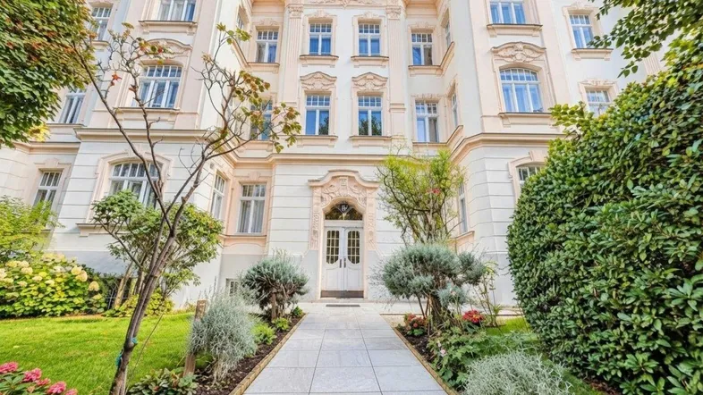 Elegante Fassade eines Altbaus mit gepflegtem Vorgarten und klassischer Architektur.