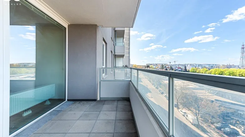 Geräumiger Balkon mit Fliesenboden und Glasgeländer bietet einen weiten Blick über die Stadt.