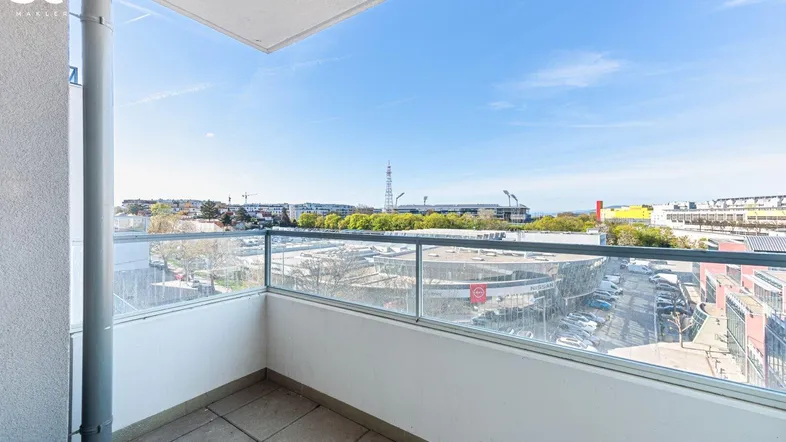 Heller Balkon mit Glasbrüstung und weitem Blick über die Stadtlandschaft.