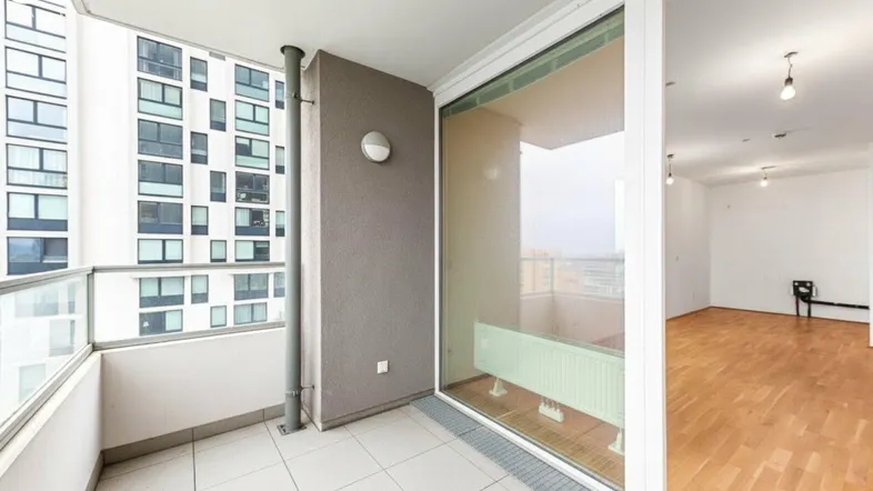 Heller Balkon mit Fliesenboden und Blick auf die umliegenden Gebäude und die Stadt.