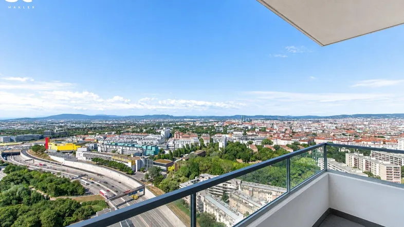 Großer Balkon mit Glasgeländer bietet einen weiten Blick über die Stadt und die umliegende Landschaft.