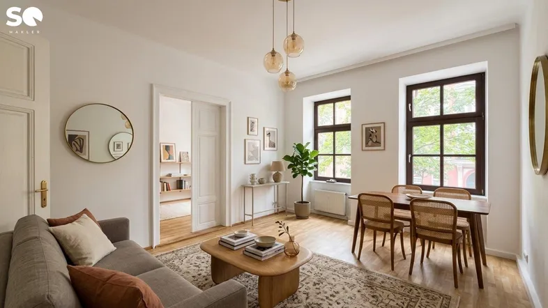 Helles Wohn- und Esszimmer mit Holzboden, modernen Möbeln und dekorativen Elementen.