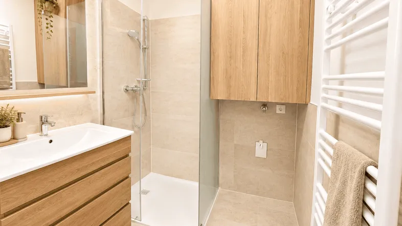 Modernes Badezimmer mit begehbarer Dusche, Holzwaschtisch und Handtuchheizkörper.