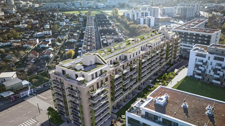 Luftaufnahme eines modernen Wohnkomplexes mit begrünten Dächern und städtischer Umgebung.