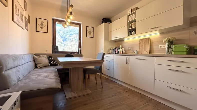 Moderne Küche mit Essbereich, Holzboden und Fenster mit Bergblick, ideal für gemütliche Mahlzeiten.