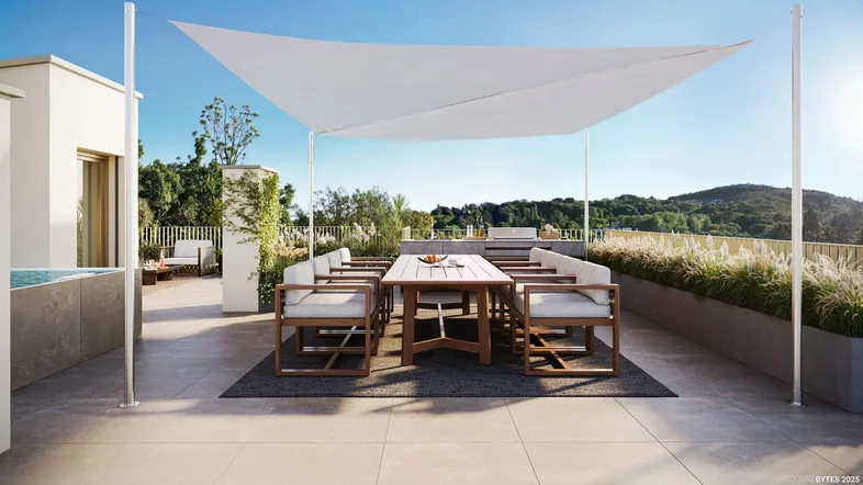 Große Dachterrasse mit Essbereich, Sonnensegel und Blick auf die grüne Umgebung.
