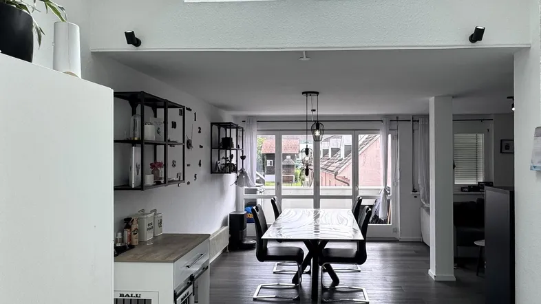 Lichtdurchfluteter Essbereich mit großem Tisch, Dachfenstern und modernem Ambiente.