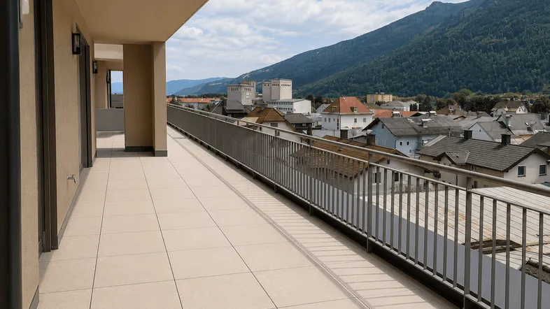 Langer Balkon mit Fliesenboden, Metallgeländer und weitem Blick über die Stadt und Berge.