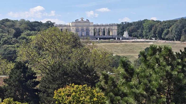 Majestätisches Gebäude mit klassischer Architektur, umgeben von üppigem Grün und weitem Blick.