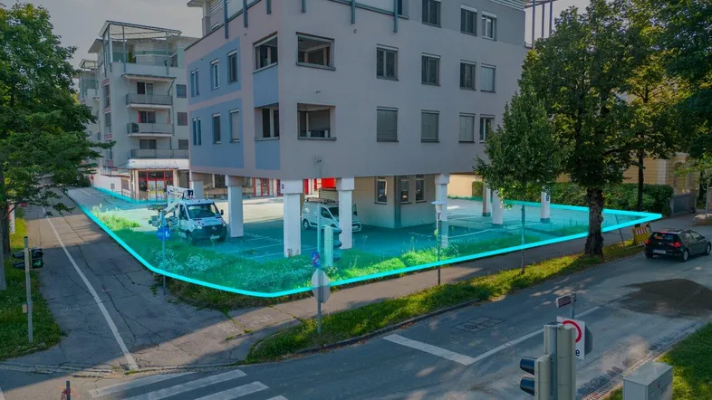 Luftaufnahme eines modernen Gebäudes mit markiertem Grundstück und umliegender Straße.
