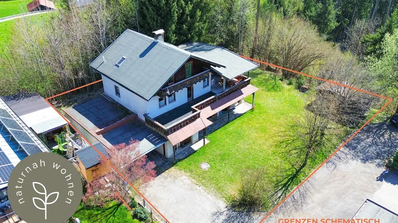 Luftaufnahme eines Hauses mit großem Grundstück und viel Grün, umgeben von Bäumen.