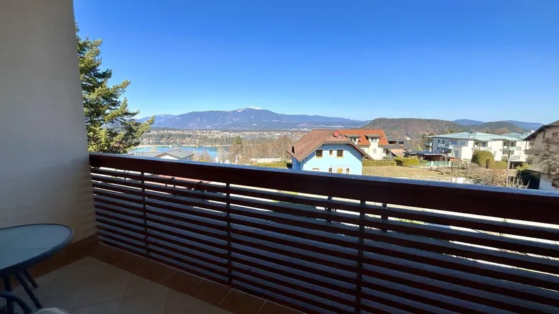 Geräumiger Balkon mit Fliesenboden und atemberaubendem Blick auf den See und die umliegenden Berge.