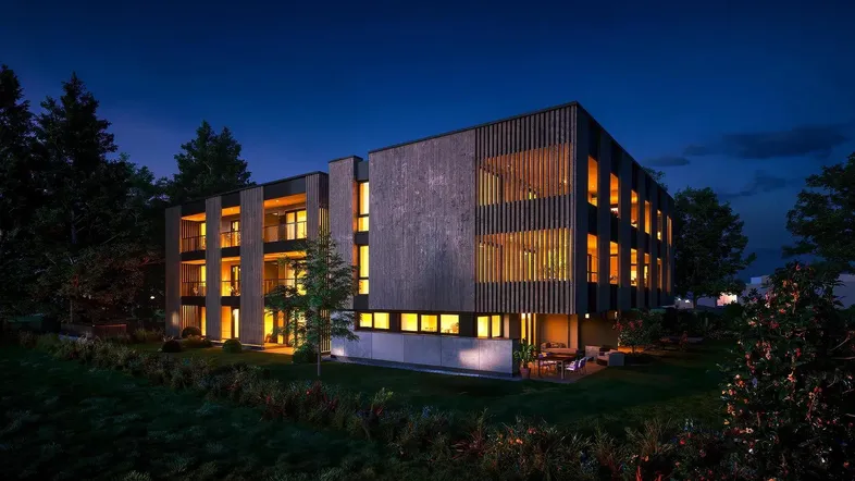 Modernes Gebäude bei Nacht mit beleuchteten Innenräumen und Holzfassade, umgeben von Bäumen.