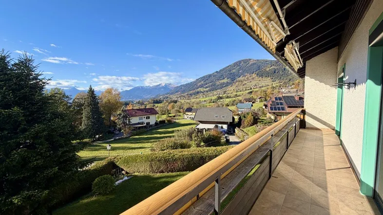 Geräumiger Balkon mit Markise und atemberaubendem Blick auf die umliegende Berglandschaft.