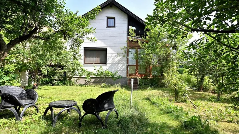 Gepflegter Gartenbereich mit Sitzgelegenheiten und Blick auf das charmante Einfamilienhaus.