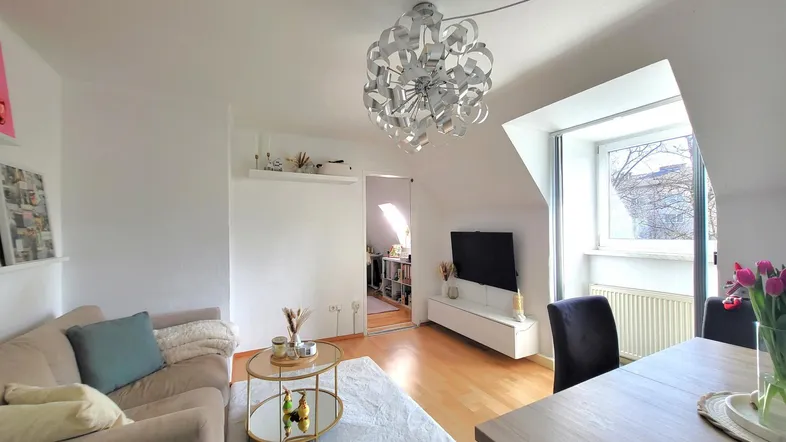Gemütlicher Wohnbereich mit Sofa, Couchtisch und Blick auf den Essbereich.