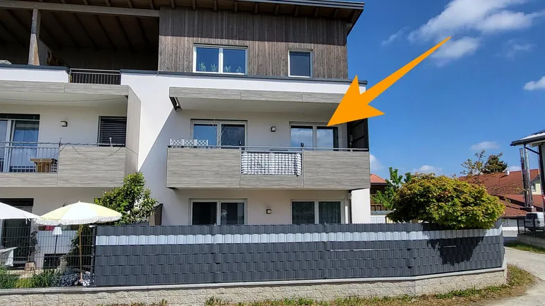 Moderne Wohnanlage mit mehreren Balkonen und Holzverkleidung unter dem Dach.