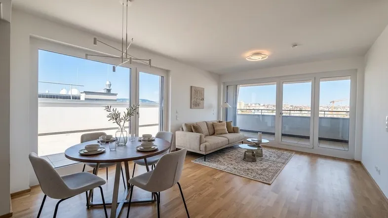 Helles, offenes Wohn-Esszimmer mit Holzboden, großen Fenstern und Zugang zur Terrasse.