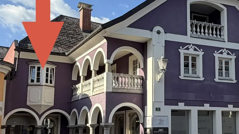 Lila Gebäude mit traditioneller Architektur, Bögen und Balkonen, ein markanter Blickfang in der Stadt.