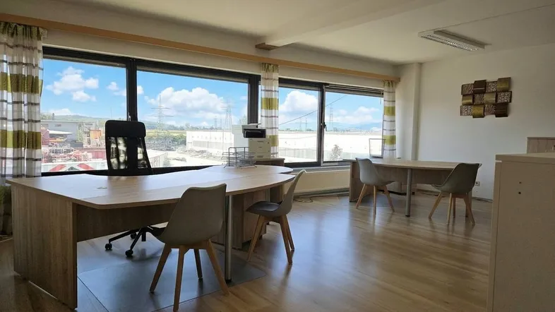 Geräumiges Büro mit großen Fenstern, die viel Tageslicht hereinlassen und einen weiten Blick bieten.
