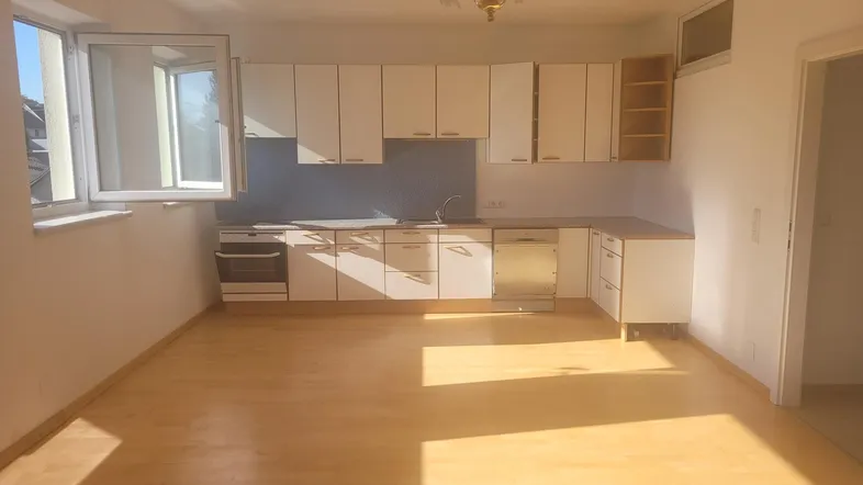 Helle Küche mit Einbauküche, Fenster und viel Tageslicht, ideal für einen Essbereich.