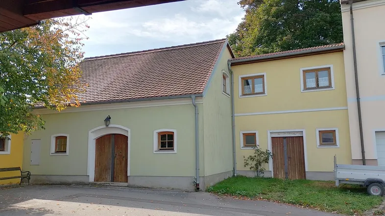 Fassade eines traditionellen Gebäudes mit hellgelbem und hellgrünem Anstrich und Holztüren.