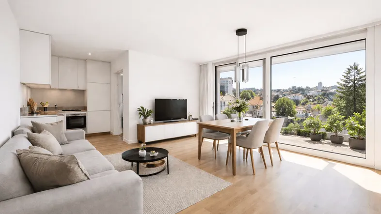 Heller, offener Wohn- und Essbereich mit moderner Küche, Parkettboden und Zugang zur Terrasse mit Weitblick.