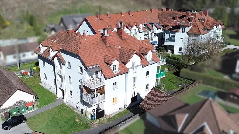 Übersicht der Wohnanlage aus der Vogelperspektive mit Gärten und Spielplatz.