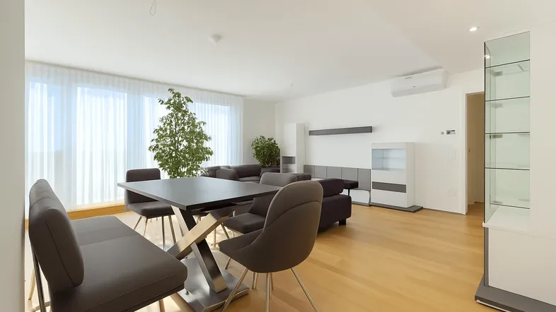 Helles und modernes Wohn-Esszimmer mit Holzboden, großem Esstisch und bequemer Sitzecke.