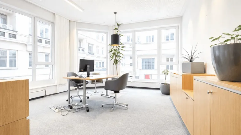 Helles und modernes Büro mit großen Fenstern, Teppichboden und Holzschränken, ideal für produktives Arbeiten.