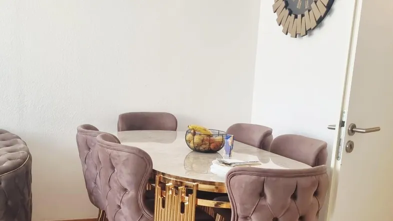 Eleganter Essbereich mit ovalem Tisch, gepolsterten Stühlen und modernem Design.