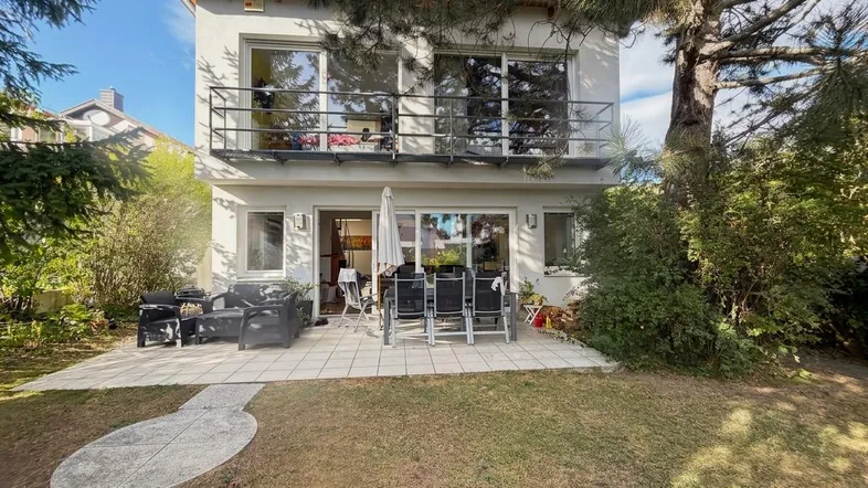 Geräumige Terrasse mit Gartenmöbeln und Zugang zum gepflegten Garten hinter dem Haus.