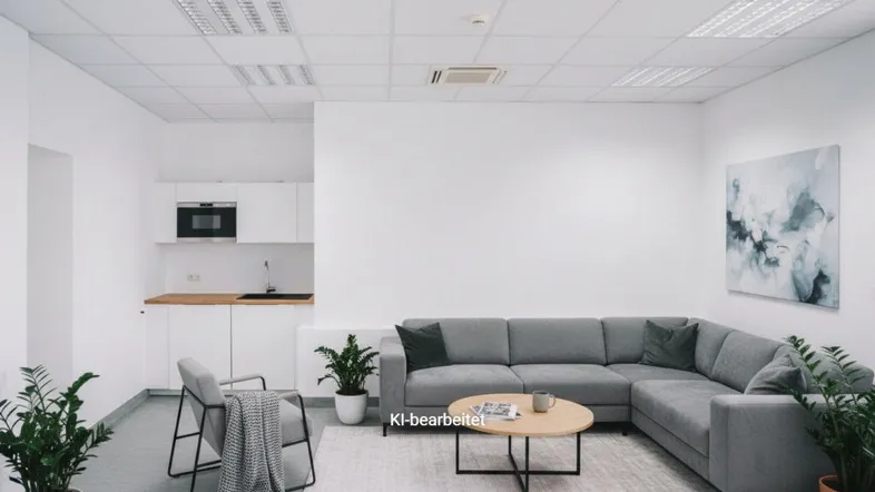 Moderner Büroraum mit integrierter Küchenzeile und gemütlicher Lounge-Ecke für Pausen.