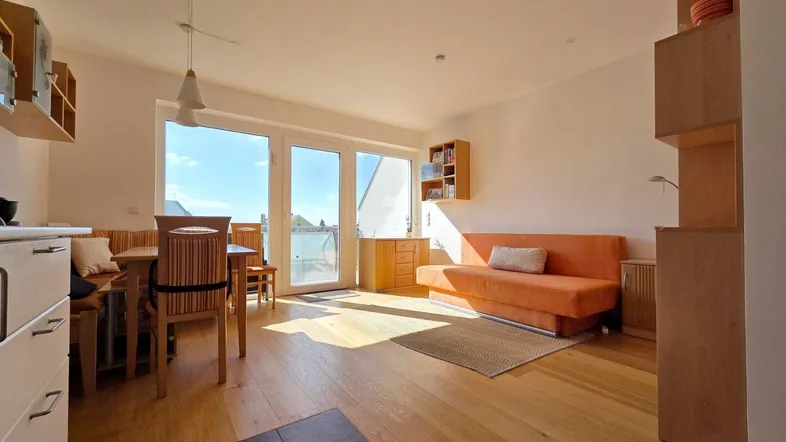 Helles Wohn- und Esszimmer mit Holzboden, Zugang zur Terrasse und viel Tageslicht.
