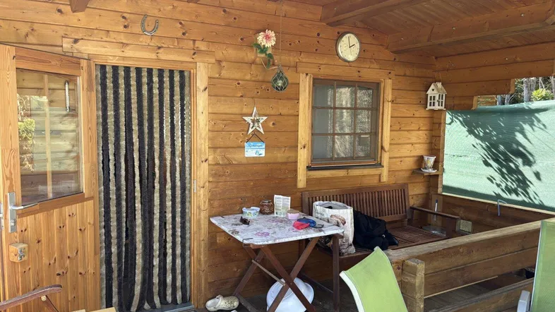 Überdachte Holzterrasse mit rustikalem Charme und gemütlicher Sitzecke.