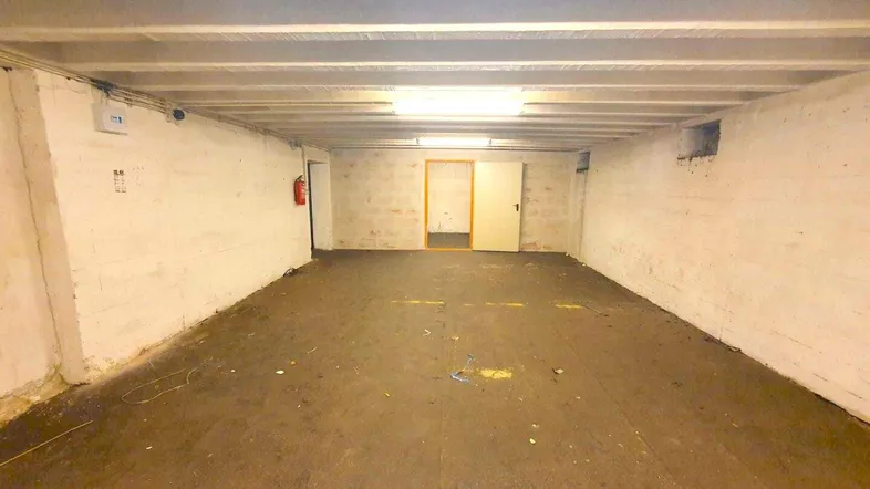 Geräumiger Kellerraum mit sichtbaren Deckenbalken und einfachen Wänden, ideal für Lagerzwecke.