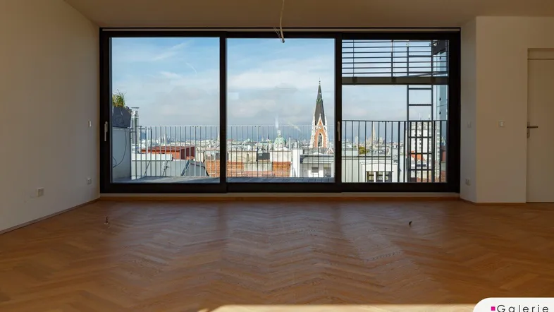 Heller Wohnraum mit Fischgrätparkett und großen Fenstern mit Stadtblick.