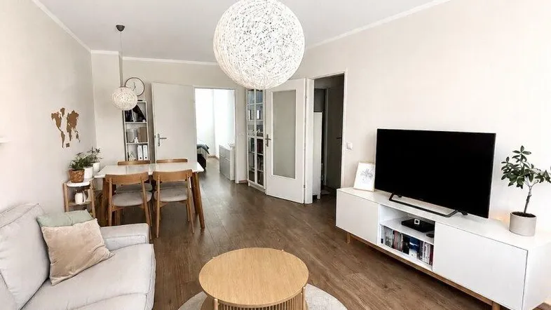 Geräumiger Wohn- und Essbereich mit hellem Laminatboden und moderner Einrichtung.