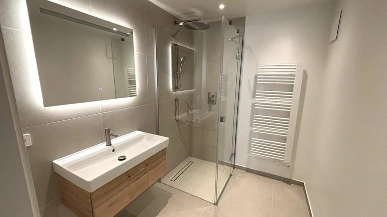 Modernes Badezimmer mit begehbarer Dusche, Einzelwaschbecken und beheiztem Handtuchhalter.