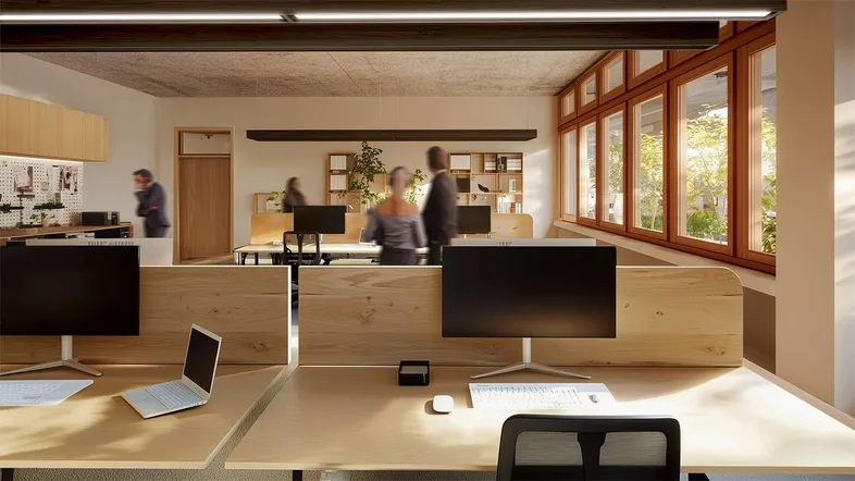Modernes Großraumbüro mit Holzmöbeln, großen Fenstern und natürlichem Licht für eine angenehme Arbeitsatmosphäre.