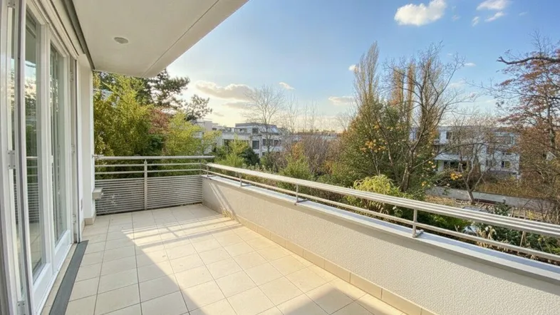 Geräumiger Balkon mit Fliesenboden und Blick ins Grüne, ideal für entspannte Stunden im Freien.